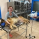 куче Тино лежи на ветеринарната маса хванат за лапите с вързана муцуна в очаване на процедурата